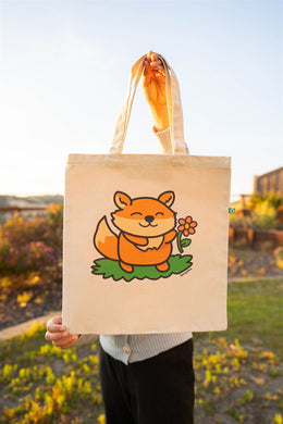 A Fox and Flower Tote Bag is a charming accessory that combines the playful imagery of a fox with the natural beauty of flowers. These tote bags often feature illustrations or designs depicting foxes amidst floral patterns, creating a whimsical and nature-inspired aesthetic. Crafted from durable materials like canvas or linen, they are both functional and stylish, suitable for carrying everyday essentials or serving as a unique gift for nature and animal lovers.