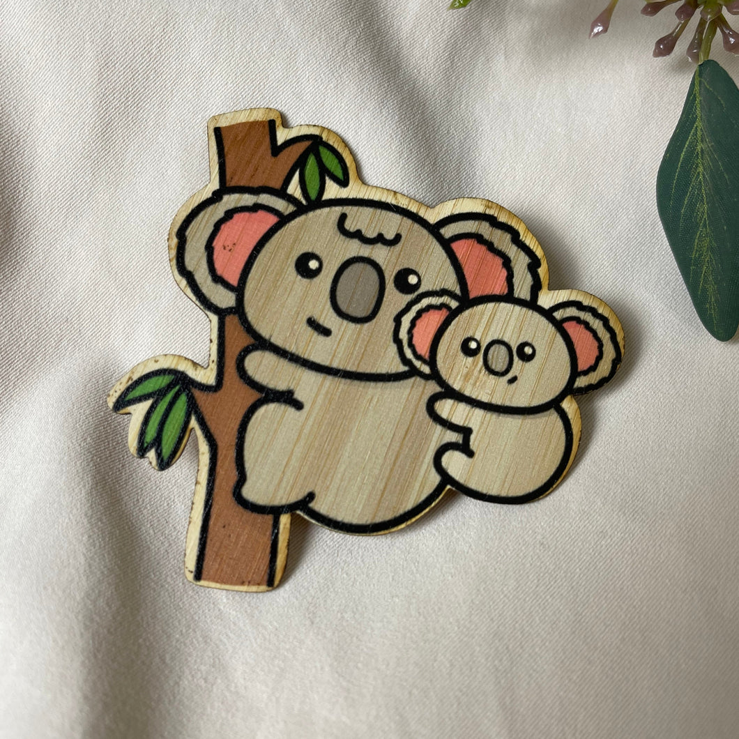 Koala mom gracefully hanging off a branch, carrying her adorable baby on her back, captured in our bamboo sticker artwork. 🐨🌿 #KoalaArt #BambooSticker #WildlifeLove