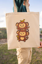 Load image into Gallery viewer, A playful design featuring two adorable monkey twins hanging from a leafy branch, their tails curled together in a sweet embrace. Printed on a durable, eco-friendly tote bag, perfect for carrying books, groceries, and daily essentials. A fun and charming choice for monkey lovers
