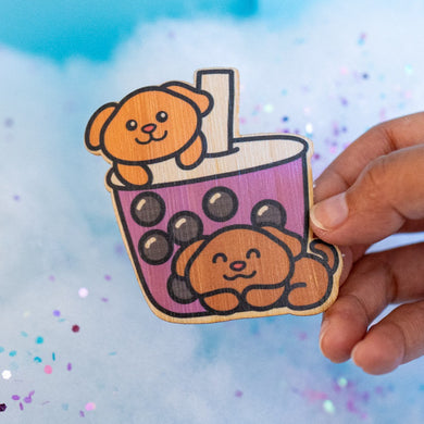 An adorable group of puppies playfully peeking out of a boba tea cup, with tapioca pearls at the bottom. This eco-friendly bamboo sticker features a cute, hand-drawn style, perfect for decorating laptops, water bottles, and notebooks! 🐶🧋✨