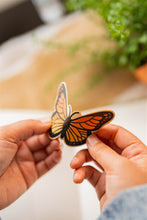 Load image into Gallery viewer, Monarch Butterfly Bamboo Sticker - Dynamic image capturing the sticker being bent to highlight its flexibility and durability.
