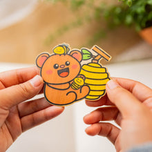 Load image into Gallery viewer, Bamboo Sticker of a Bear with a beehive and bees, happy, smiling, yellow, brown  bear with two little bees and a bee hive
