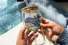 Load image into Gallery viewer, Belugabee Dreamy Whale Bamboo Sticker: Charming design of dreamy whales on a glass cup, adding a touch of underwater magic to your drinkware. Elevate your style with this adorable 3x3-inch bamboo sticker. 🐋✨ #BambooSticker #DreamyWhale #GlassCupDecor
