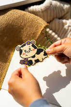 Load image into Gallery viewer, Belugabee Bamboo Wood Sticker: Happy cow with a bright smile amidst lovely purple flowers. Elevate your style with this eco-friendly 3x3-inch sticker. 🐮🌸 #BambooWoodSticker #HappyCowAndFlowers #NatureInspiredArt
