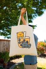 Load image into Gallery viewer, Kittens Boba Tote Bag being carried by a stylish individual, showcasing the cute feline design and adding a touch of whimsy to your daily outings. 🐱👜 #KittensBoba #ToteBagStyle #BambooArtistry
