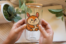 Load image into Gallery viewer, Belugabee Bamboo Sticker: Adorable brown bunny rabbit perched on a glass cup. Elevate your style with this eco-friendly 3x3-inch sticker. 🐰🥤 #BambooSticker #BunnyOnGlassCup
